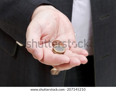 pile of coins in businessman\'s hand close up