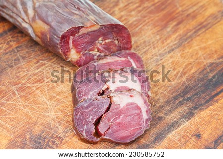 sliced horse meat sausage kazi close up on cutting wooden board