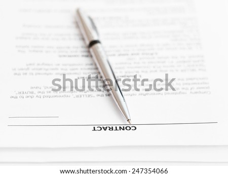 pages of sales contract and silver pen close up