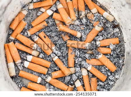 many cigarette ends in plastic pot close up