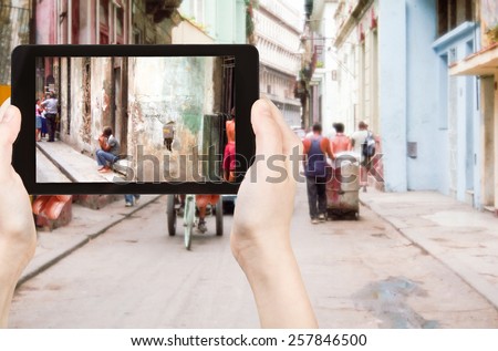 travel concept - tourist taking photo of old street in Havana on mobile gadget, Cuba