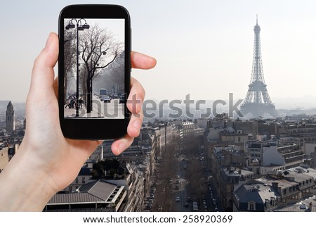 travel concept - tourist taking photo of Avenues in Paris in early spring on mobile gadget, France