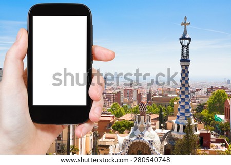 travel concept - tourist photograph skyline of Barcelona city, Spain on smartphone with cut out screen with blank place for advertising logo