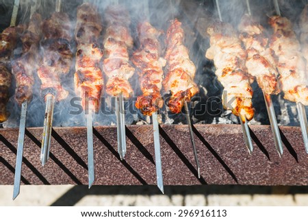 many shish kebab sticks preparing on outdoor grill