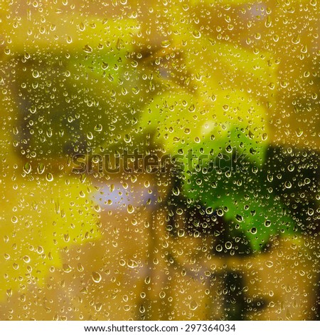 yellow background from raindrops on window pane during night rain