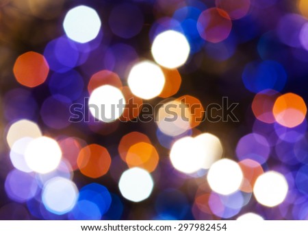 abstract blurred background - blue, red and violet shimmering Christmas lights of electric garlands on Xmas tree