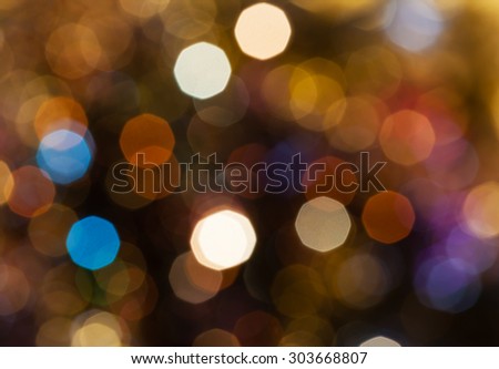 abstract blurred background - dark brown shimmering Christmas lights bokeh of electric garlands on Xmas tree