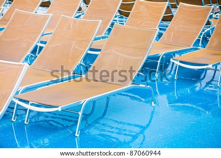 textile chairs on wet deck of cruise liner in rainy day