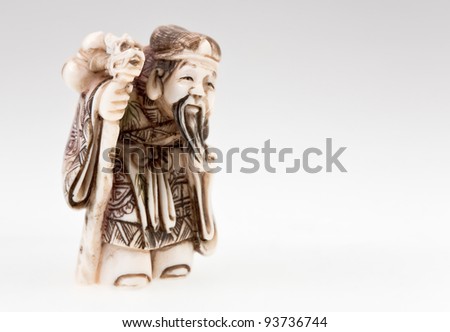statuette of Chinese  god of wealth - Tsai Shen on grey background