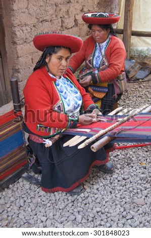 Two Peruvian women knit at a market in Peru\'s Sacred Valley on August 18, 2011.