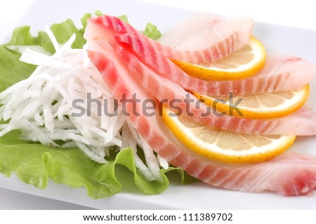 Red fish cut with slices on a dish with vegetables