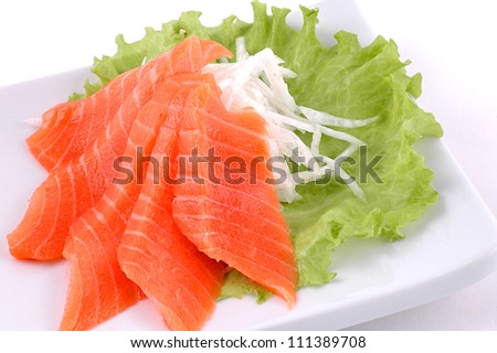Red fish cut with slices on a dish with vegetables