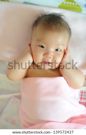 cute baby girl taking a relaxing bath with cute smile face at home, asian child