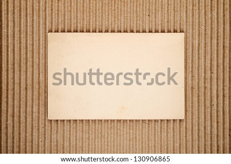 Old blank postcard on corrugated cardboard background