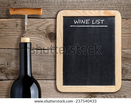 Wine list on blackboard and wine bottle on wooden background