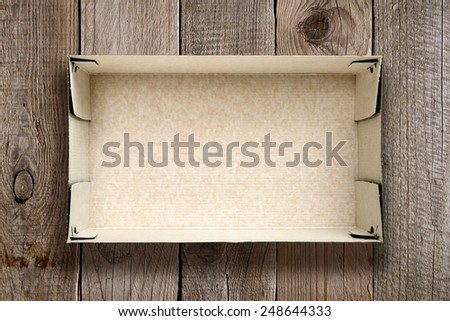 Empty cardboard box on wooden background