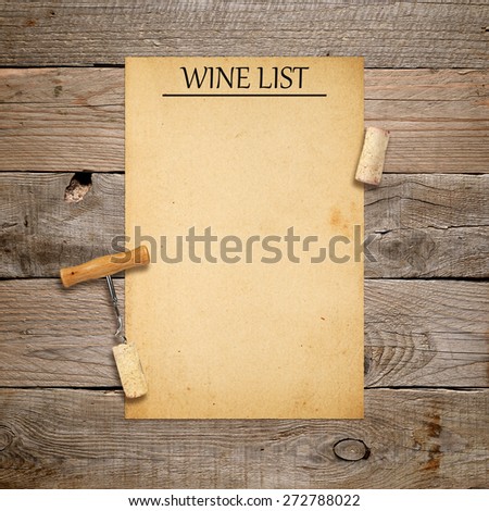 Corkscrew with cork and blank wine list on old wooden background