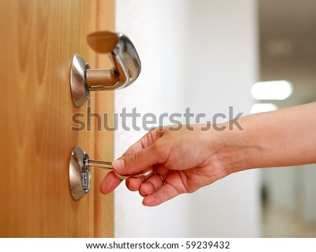 stock photo : Locking up or unlocking the door with a key in hand