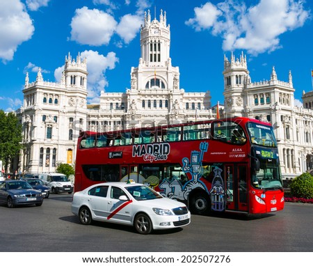 MADRID JULY 2, 2014  Cibeles Palace (Palacio de Cibeles): City Hall of Madrid (formerly Palace of Communication) and tour bus. Iiconic monument of the city.  In Madrid, Spain on July 2, 2014.