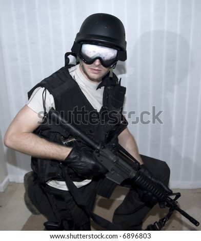 a swat police officer with helmet and m16machine gun