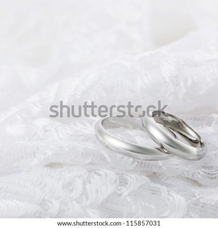 Silver rings on white lace fabric