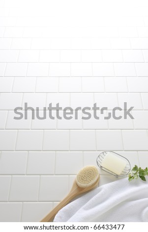 Soap,brush,and towel on white tile floor