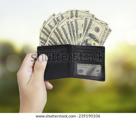 Closeup hands as he is getting a banknote out of his wallet