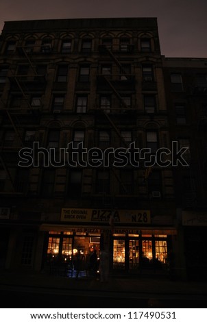 NEW YORK, NY - NOVEMBER 1: A restaurant lit by candlelight in the West Village opens during the blackout caused by Hurricane Sandy, cooks pizzas in a woodburning oven on Nov 1st 2012 in New York.