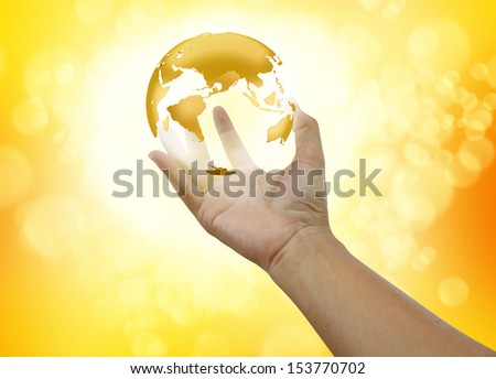 Human hands holding gold earth gold background