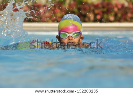 South Asian Indian boy in the swimming pool with goggles in Arab resort