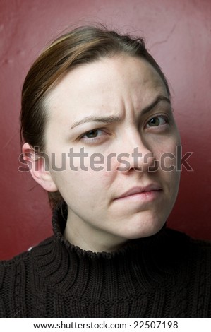 Young woman head shot, looking slightly confused
