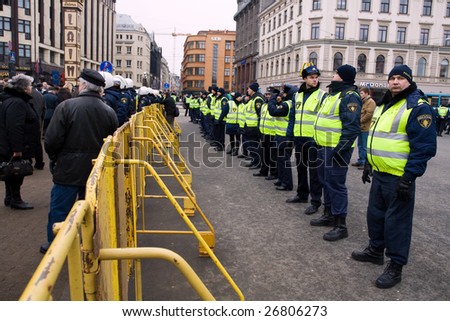 RIGA, LATVIA - MARCH 16: Local police guard behind crowd control barriers at the Freedom Monument at the commemoration of the Latvian Waffen SS unit on March 16, 2009 at Riga, Latvia.