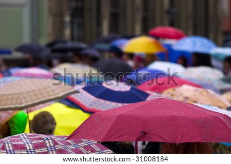 Busy street with crowd of people with umbrellas