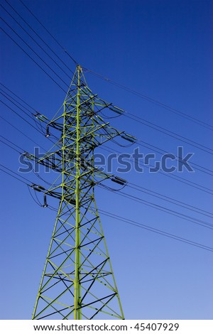 Green high voltage electric line against blue sky