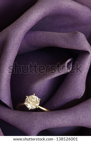 Solitaire engagement diamond ring (ideal cut) encrusted on 18K gold ring embedded in purple rose.