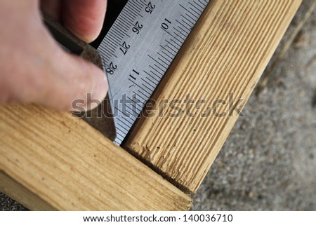 Doing calculations to ensure right angle on the wooden beam.