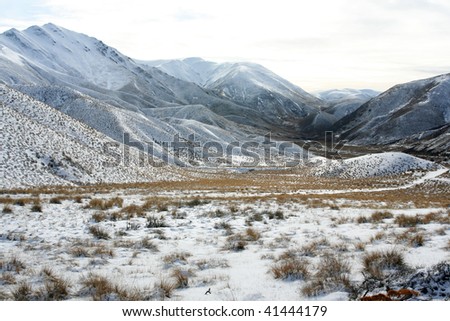 Light snow covering barren landscape in South Island, New Zealand.
