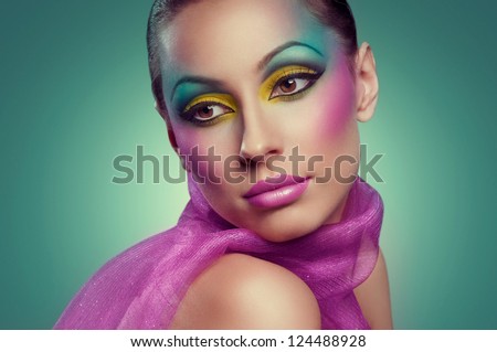 Woman face with creative many-coloured makeup