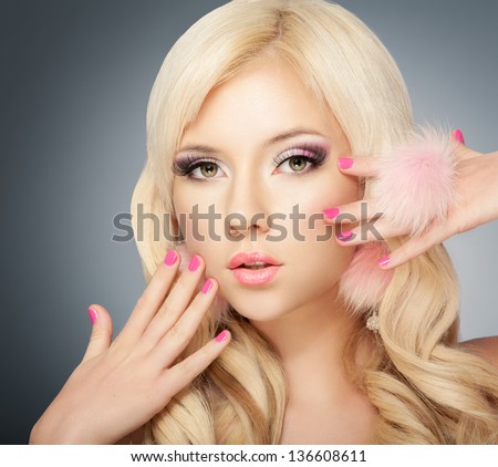 Beautiful blonde girl face with pink makeup, manicure and long eyelashes