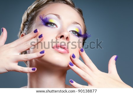 Woman face with bright violet makeup and manicure