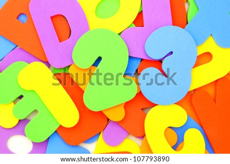 Colorful toy numbers and letters forming a background with 123 in front