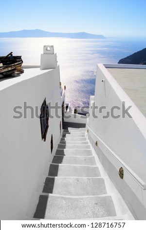 View out to sea over whitewashed stepped street in Santorini, Greece