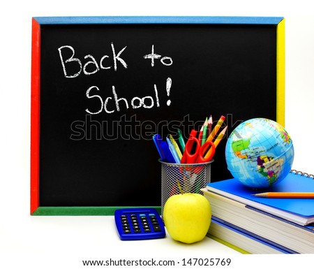 Back to School written on a blackboard with school supplies