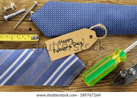 Happy Fathers Day tag with ties and tools on a wood background