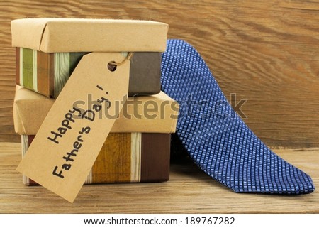 Fathers Day gifts with tag and tie over a wooden background
