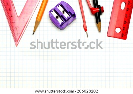 School supplies border over graphing paper background