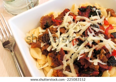 Pasta dish with sausage, sun dried tomatoes and grated cheese