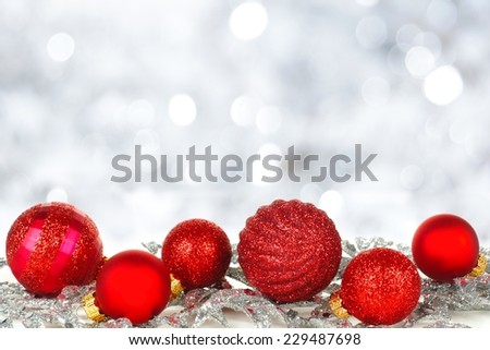 Red Christmas ornament border with twinkling silver light background