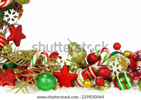 Christmas corner border of branches with red and green ornaments in snow