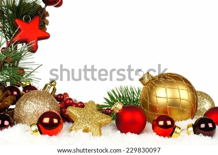 Christmas corner border of branches with red and gold ornaments in snow
